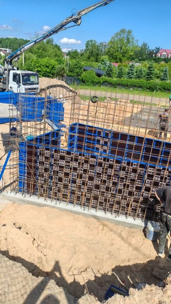 Устройство бетонных стен хозблока и подпорной стены забора